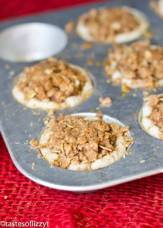 Apple Butter Pie Tarts are a great food gift for the holidays. Perfect bite-size tarts with apple butter filling and an oatmeal streusel topping! One of the best apple recipes to make for a delicious fall dessert! muffin pan full of apple butter pie tarts