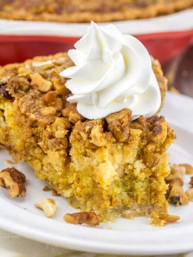 Pumpkin Crumb Pie has a traditional pumpkin pie base, with a cake mix and nut crunch streusel baked on top. This easy pumpkin recipe makes the perfect fall dessert! slice of pumpkin crumb pie with whipped cream on top