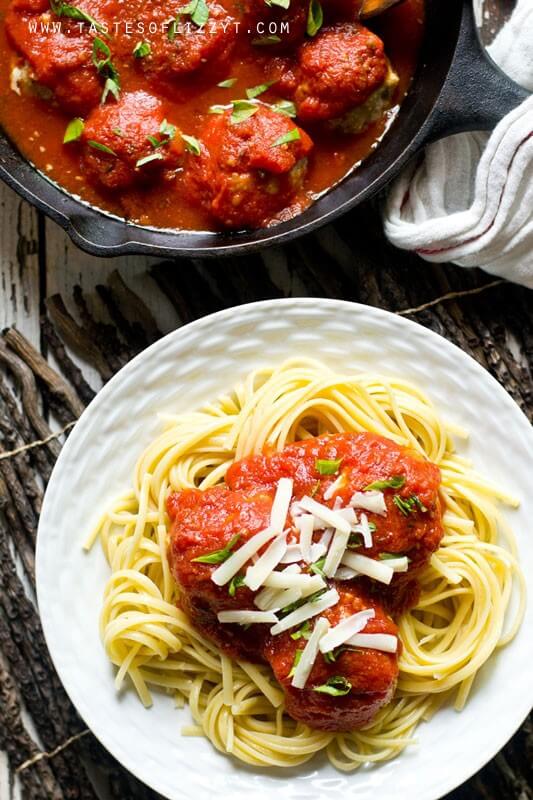 Get the classic chicken parmigiana flavor in Chicken Parmesan Meatballs. Made gluten free and sugar free for a high protein, healthy dinner. overhead photo looking down on a plate of pasta with meatballs in red gravy