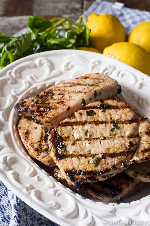 Basil Lemon Pork Chops Marinade is an easy, 4-ingredient marinade recipe that makes the most tender Grilled Basil Lemon Pork Chops. Throw ingredients together in under 5 minutes, marinate, and grill! A Paleo, Whole30, gluten free recipe for the family. #glutenfree #whole30 #paleo #porkrecipes #porkchops platter of marinated grilled pork chops