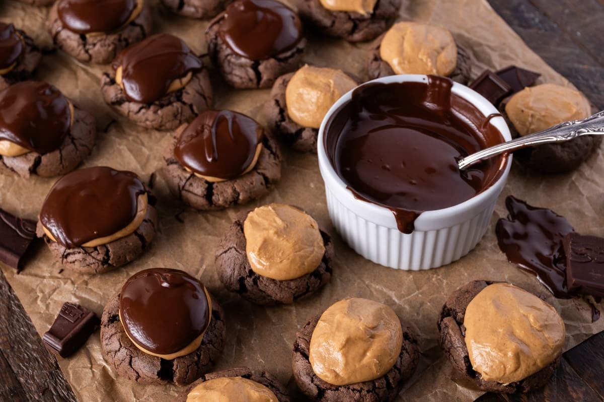 buckeye brownie cookies on a table with chocolate being drizzled on top