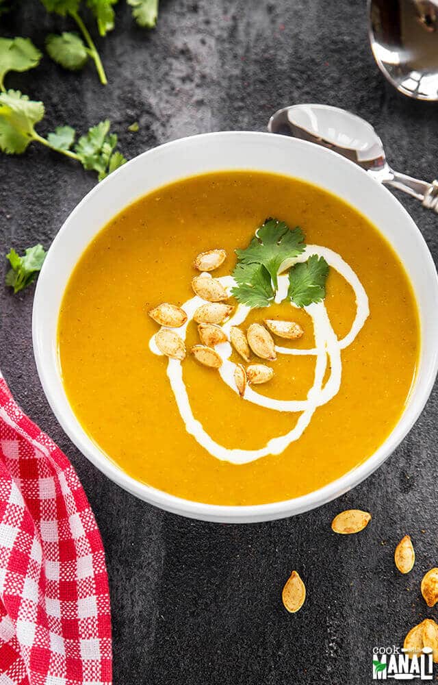 Pumpkin Apple Carrot Soup is lightly spiced, fall inspired soup recipe. It's really comforting and is an easy pumpkin recipe to make for a weeknight dinner. bowl of creamy pumpkin soup made with pumpkin, carrots and apples