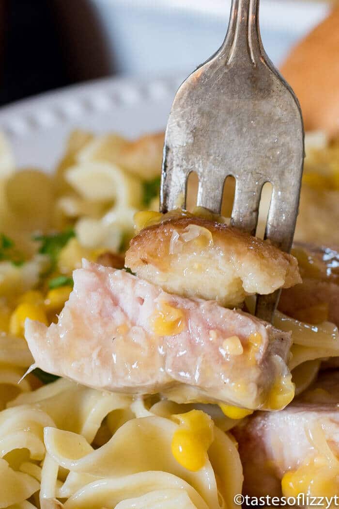 Cream Corn Pork Chops Casserole This is one of the best pork chop recipes for a quick weeknight dinner! #porkchops #porkrecipe #casserole #easydinners fork holding bites of pork chops casserole with creamed corn