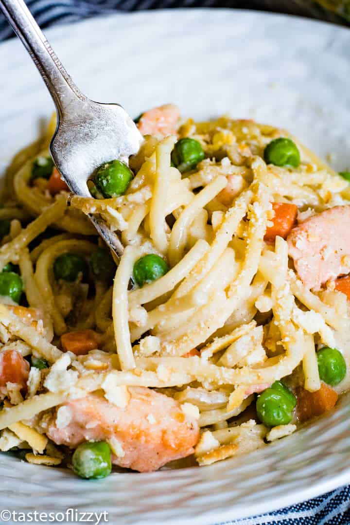 A close up of a plate of food with pasta, chicken and veggies