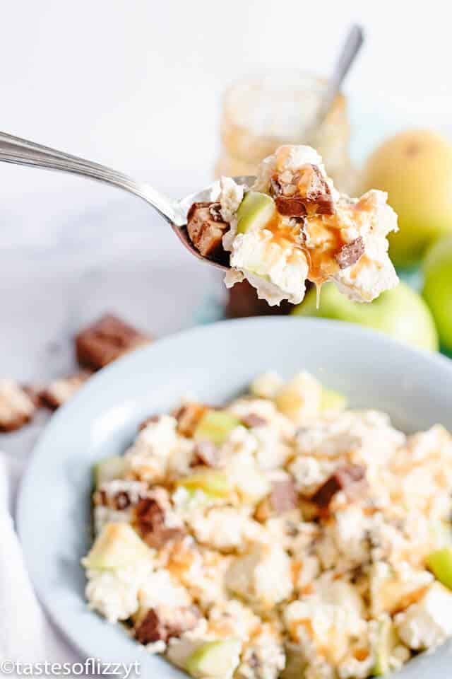 Snickers Apple Salad is an easy picnic side dish or dessert that everyone will love! Surprise your guests with this sweet dessert salad filled with candy bars, caramel and apples. It's one of the best apple recipes you can make for a party! dessert salad made with apples, vanilla pudding and Snickers candy bars