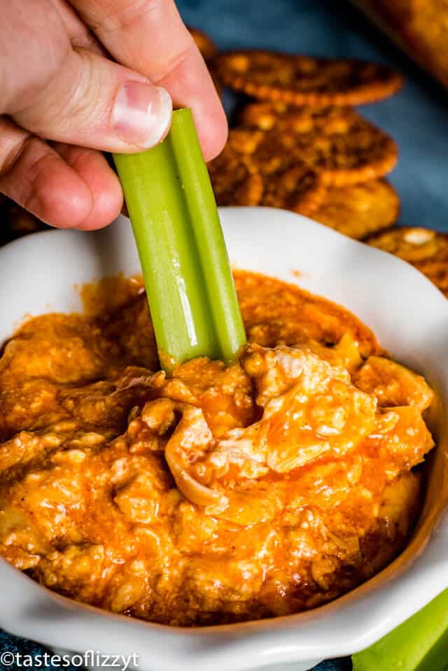 A person celery in buffalo chicken dip