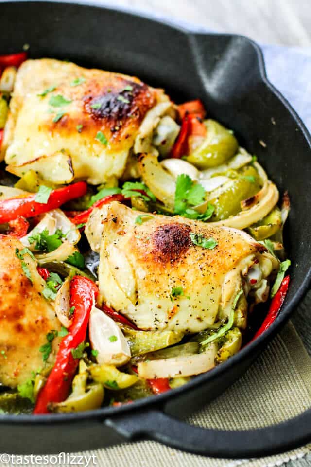 Italian Chicken Skillet is one of our favorite chicken skillet recipes. Chicken thighs with an Italian dressing marinade, oven-baked to juicy perfection. #skilletmeals #chickenrecipes #Italianchicken chicken thighs and bell peppers cooking in a cast iron skillet