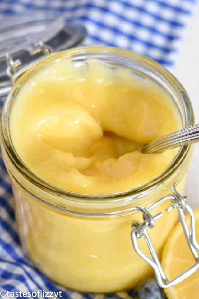 This lemon curd recipe is quick and easy to make and the sweet lemon condiment is so versatile! You can use it to make lemon desserts, or enjoy it for breakfast! It's delicious on toast, biscuits, pancakes, and more! mason jar of lemon curd with a spoon in it