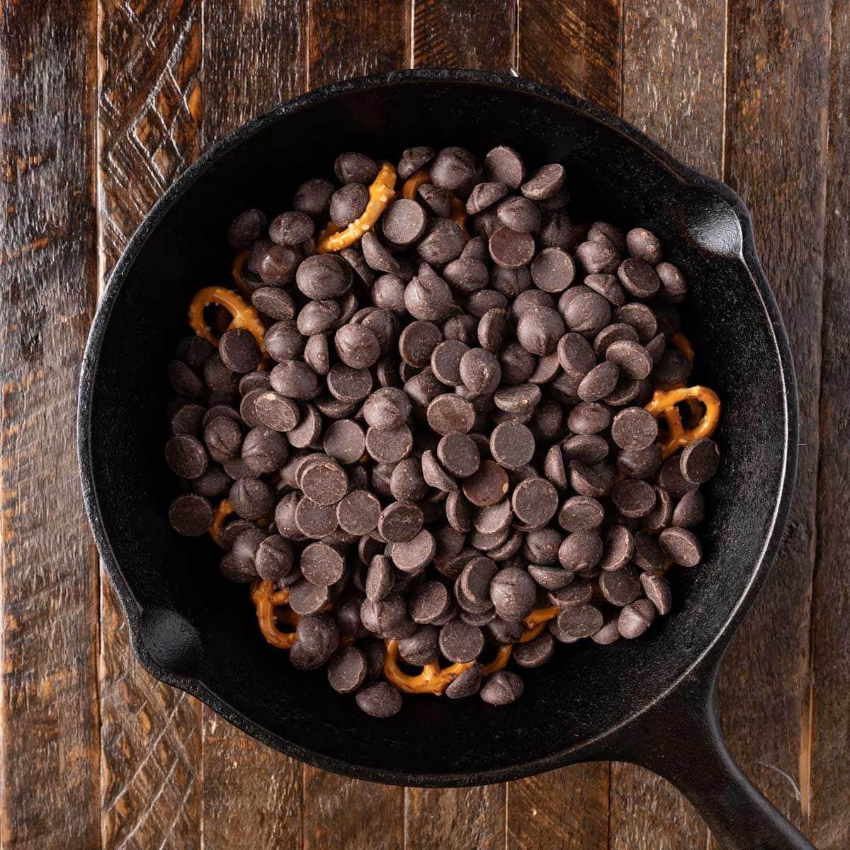 chocolate chips over pretzels in a cast iron skillet