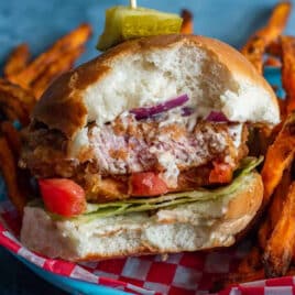 a fried pork tenderloin sandwich with a bite out of it