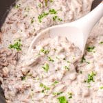 hamburger gravy in a skillet with a spoon