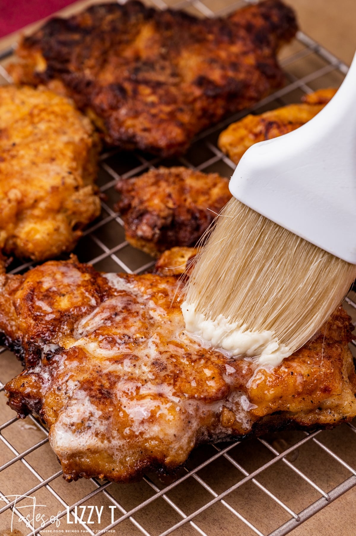 brushing honey butter over fried chicken