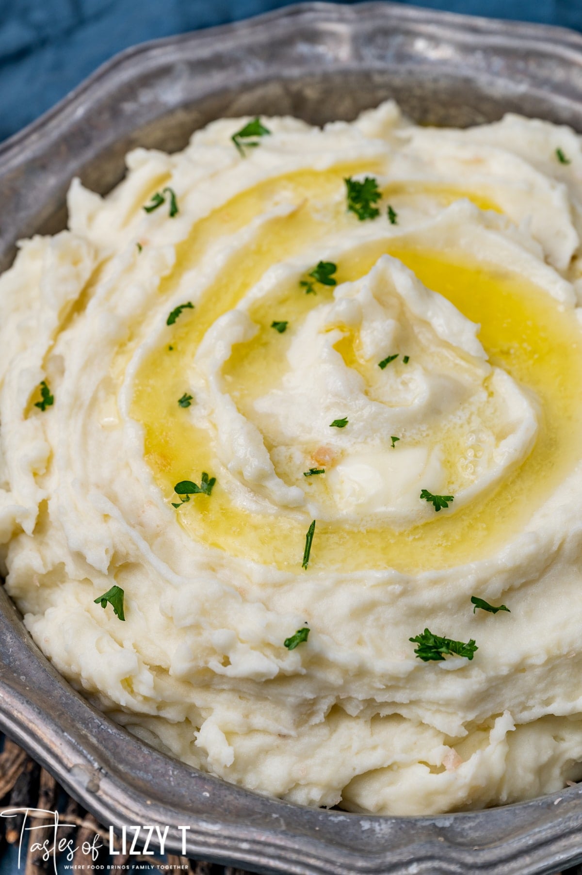 mashed potatoes in a bowl with butter and parsley on top