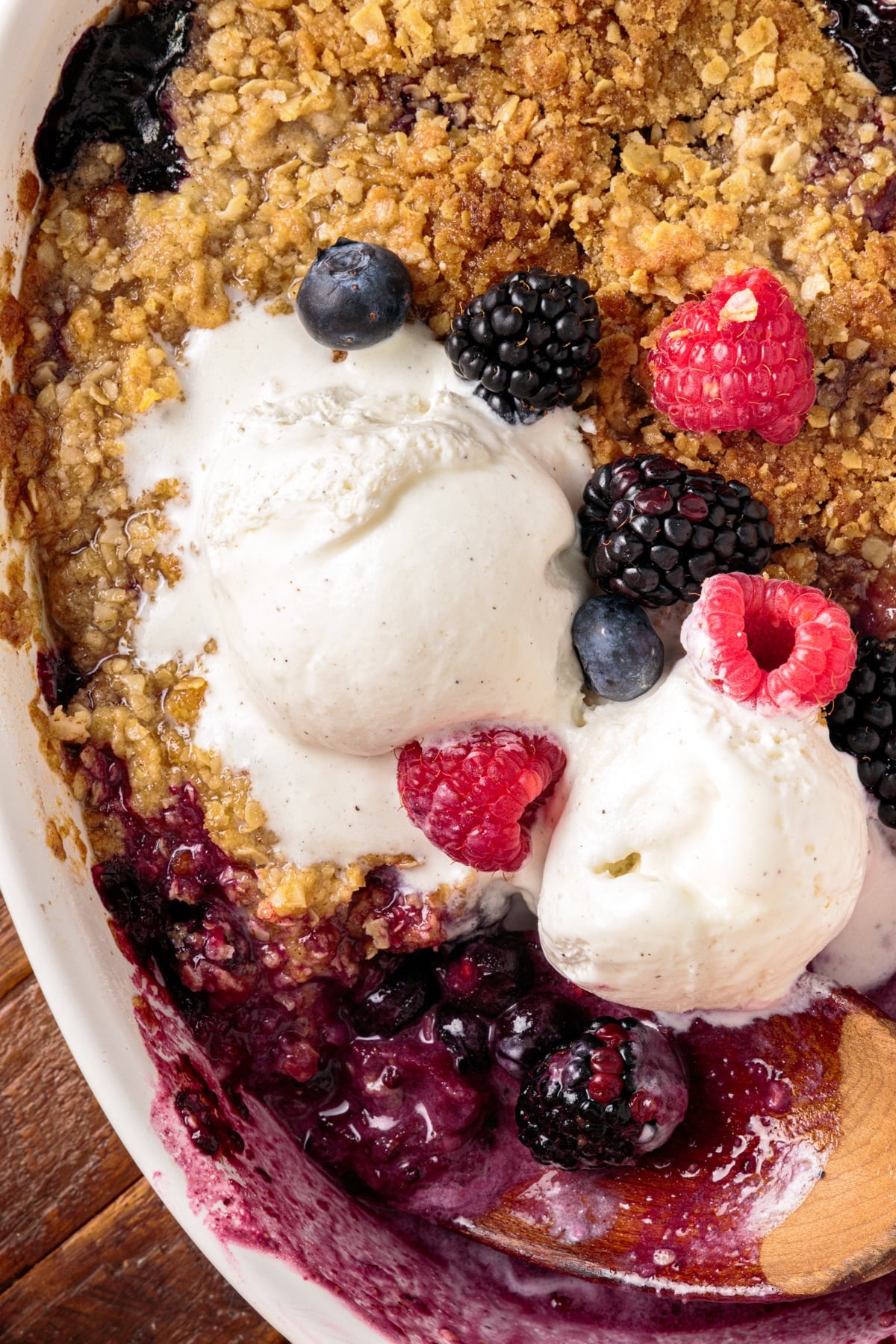 overhead view of mixed berry fruit crisp with ice cream on top