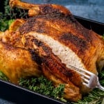 a golden brown roast chicken with a cut in it