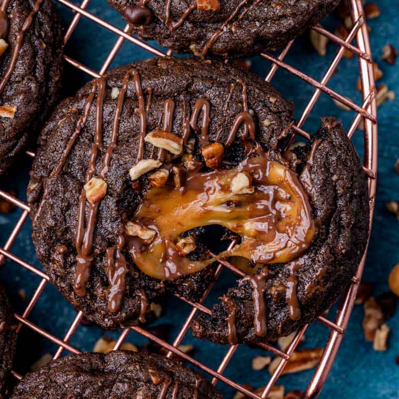 a chocolate cookie with a gooey caramel center on a wire rack