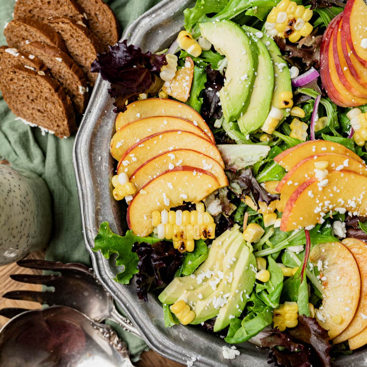 overhead view of a salad with peaches, avocado and corn