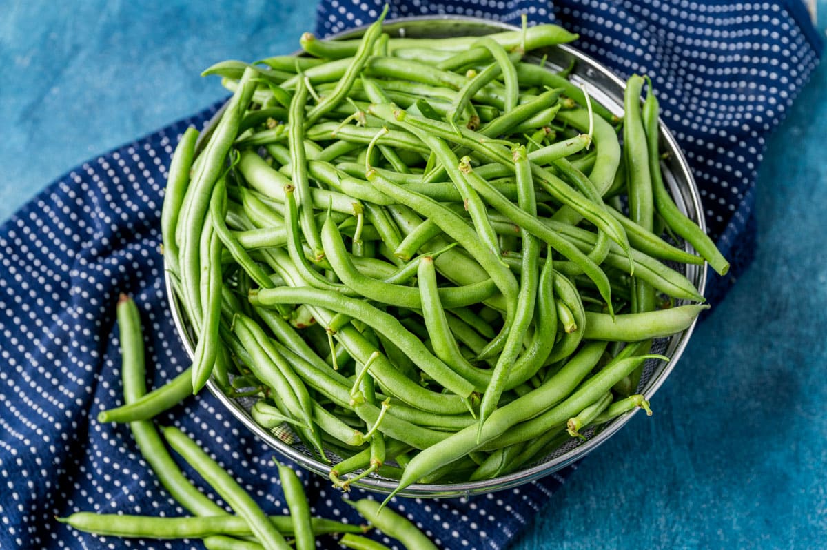 fresh garden green beans in a mesh strainer