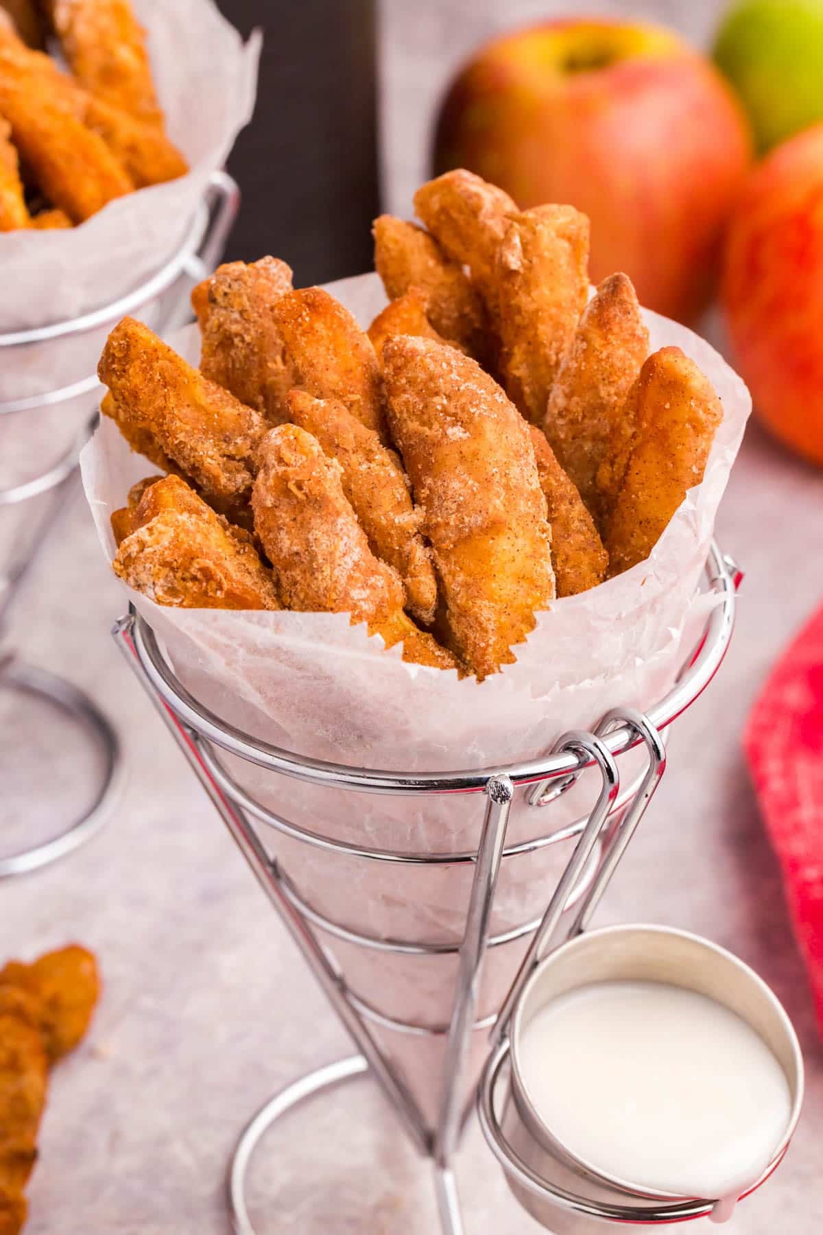 a wire cone of Air Fryer Apple Fries with vanilla glaze on the side