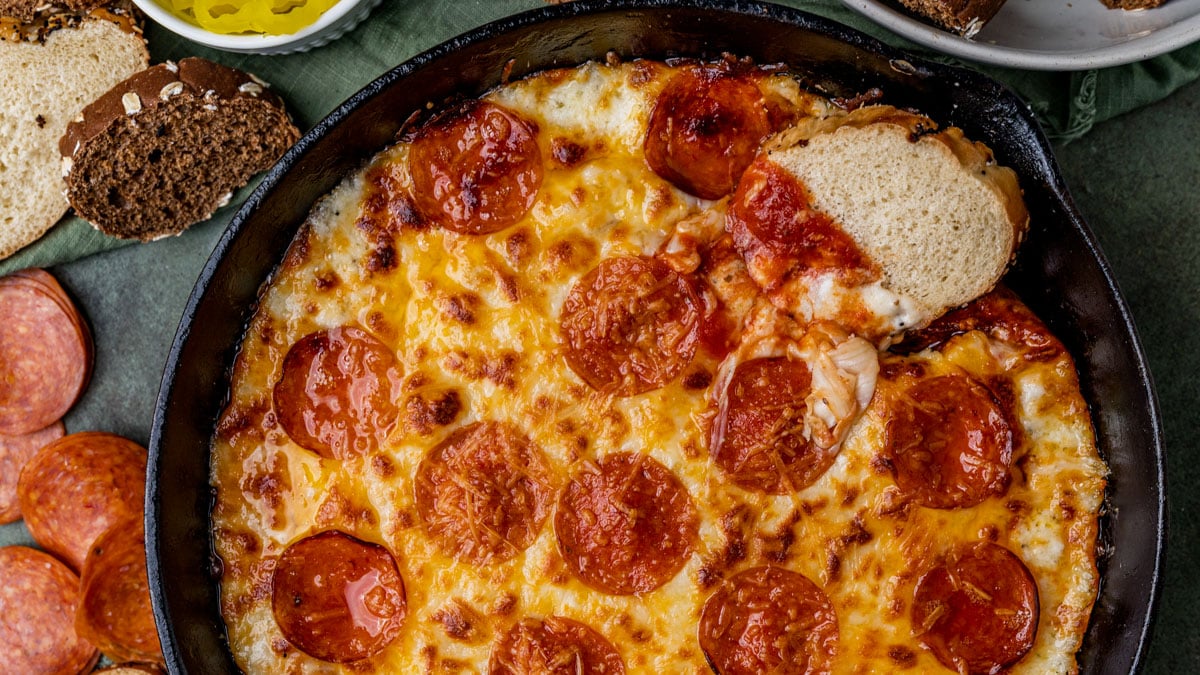 a piece of italian bread in a skillet with cheesy pizza dip