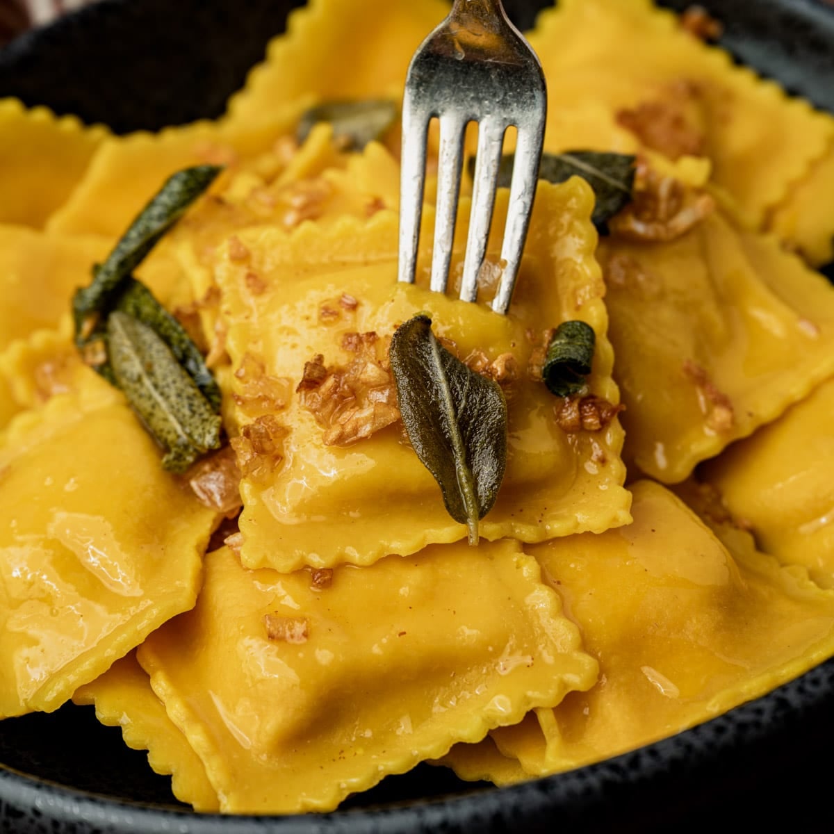 closeup of ravioli with brown butter sage sauce