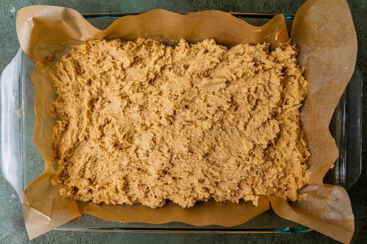 cookie dough spread in a baking pan