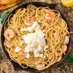 spaghetti and shrimp with parmesan cheese on top