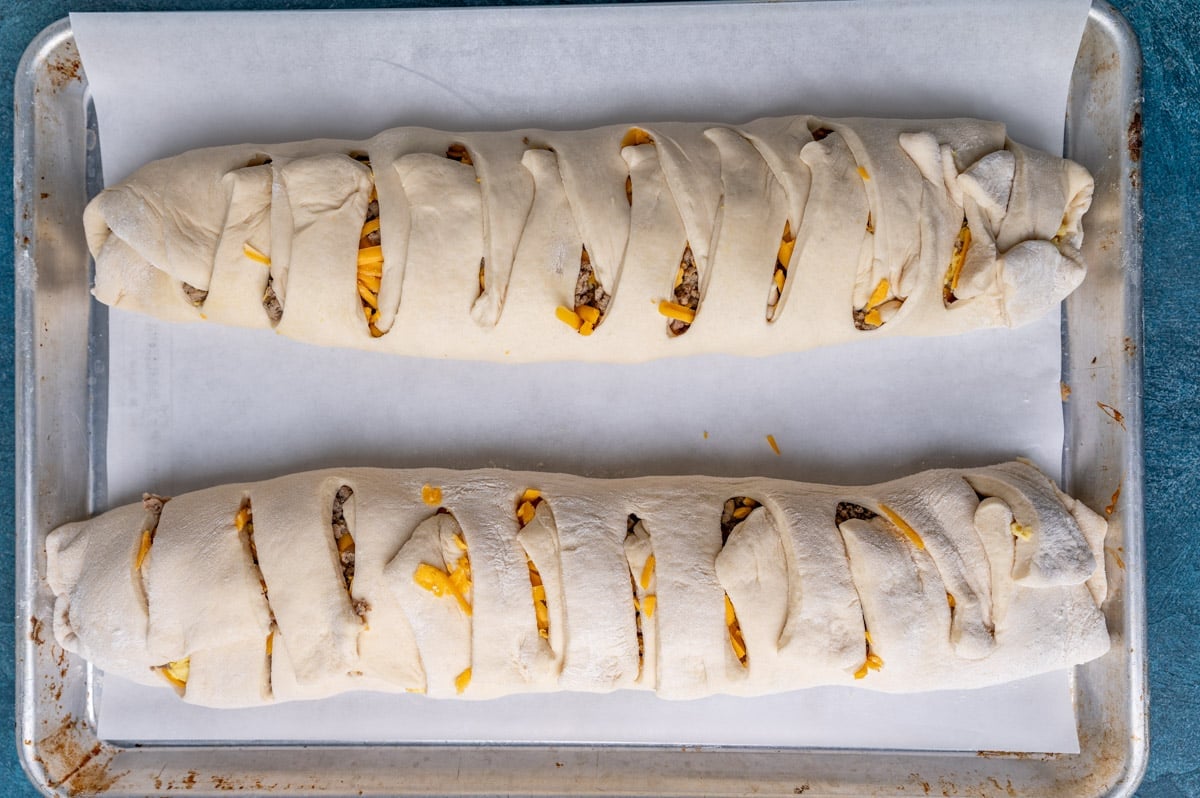 two unbaked breakfast stromboli on a baking sheet