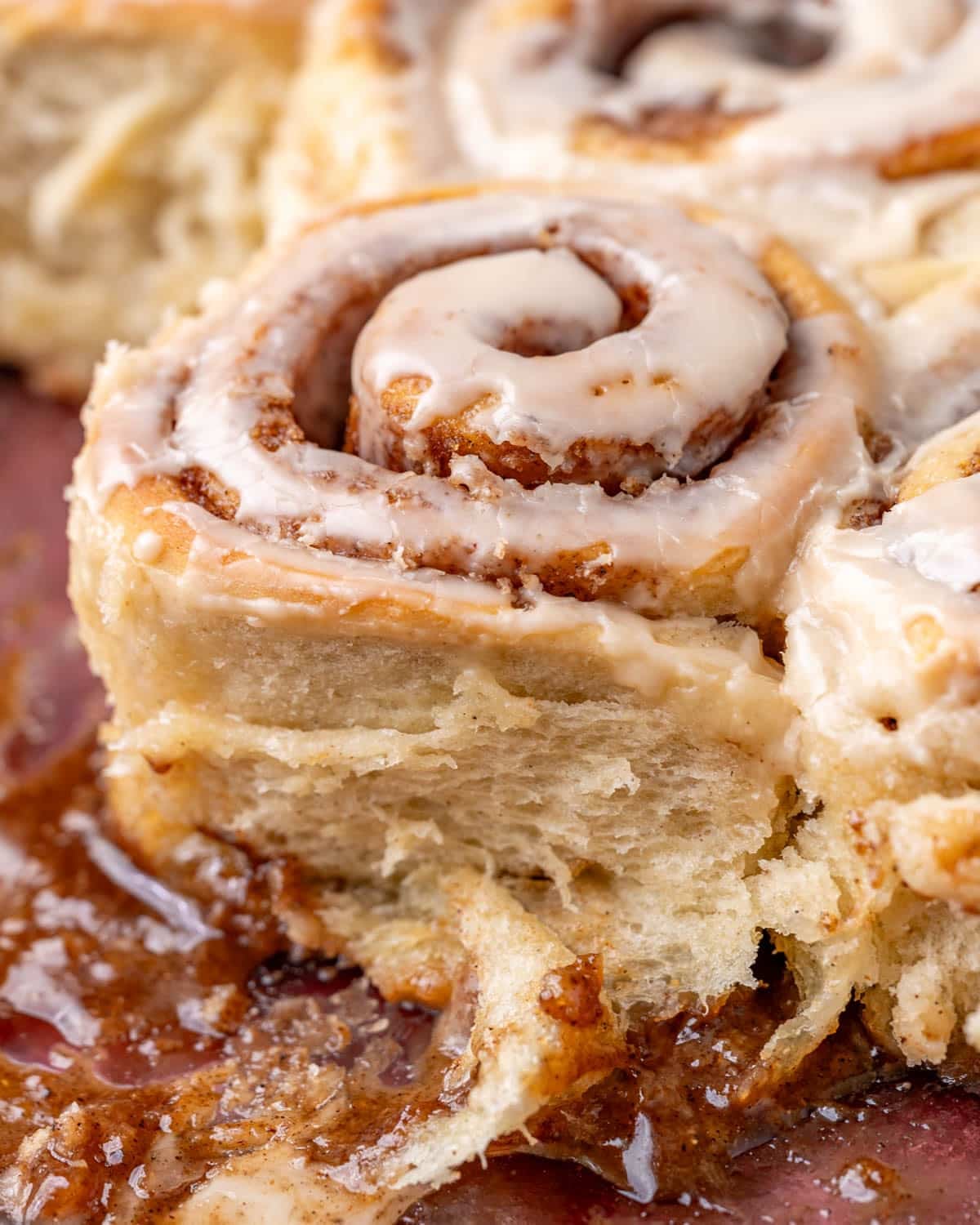 a chai cinnamon roll in a pan with a gooey cinnamon bottom