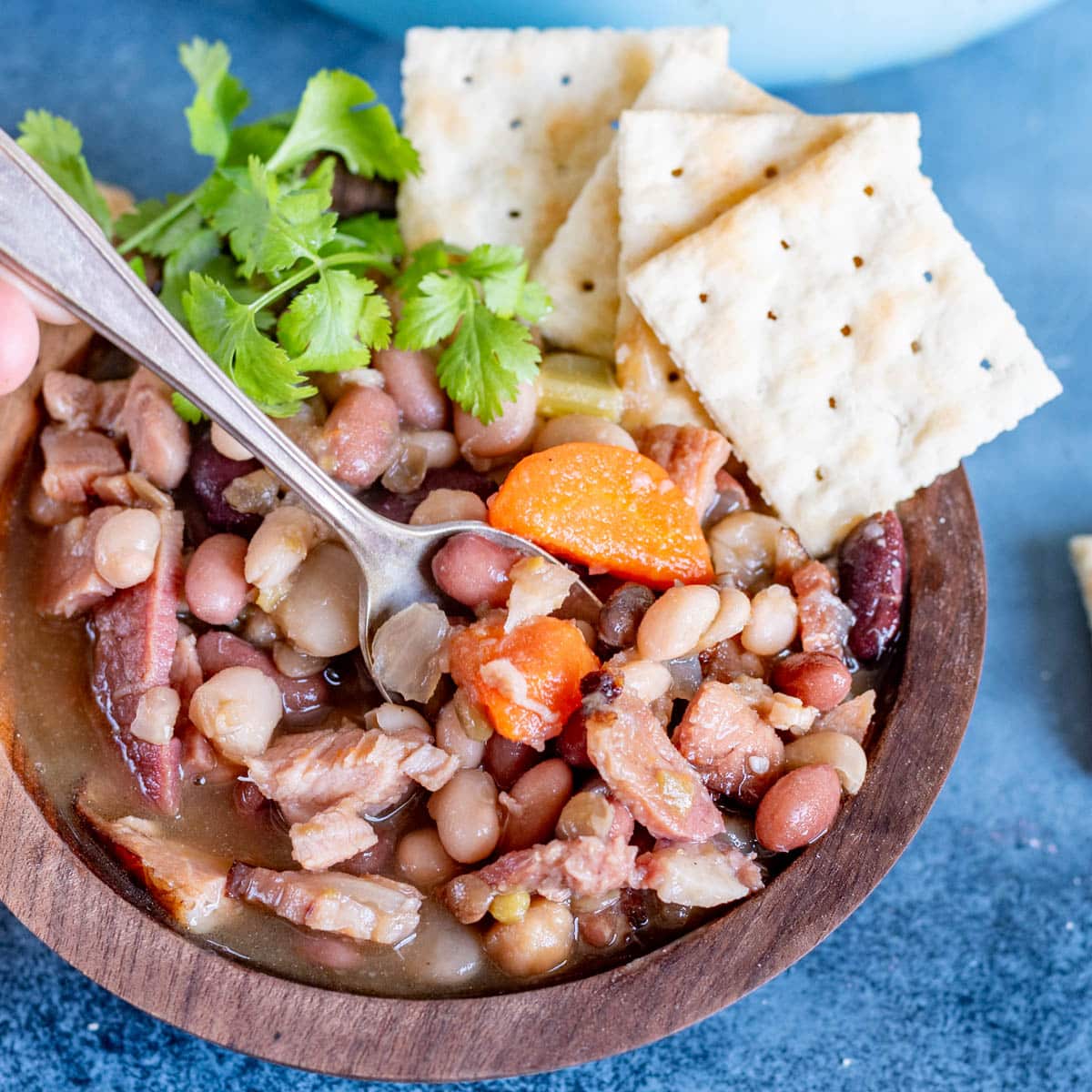 a bowl of 15 bean ham bone soup with crackers and a spoon