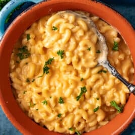 overhead view of a bowl of macaroni and cheese with fresh parsley on top