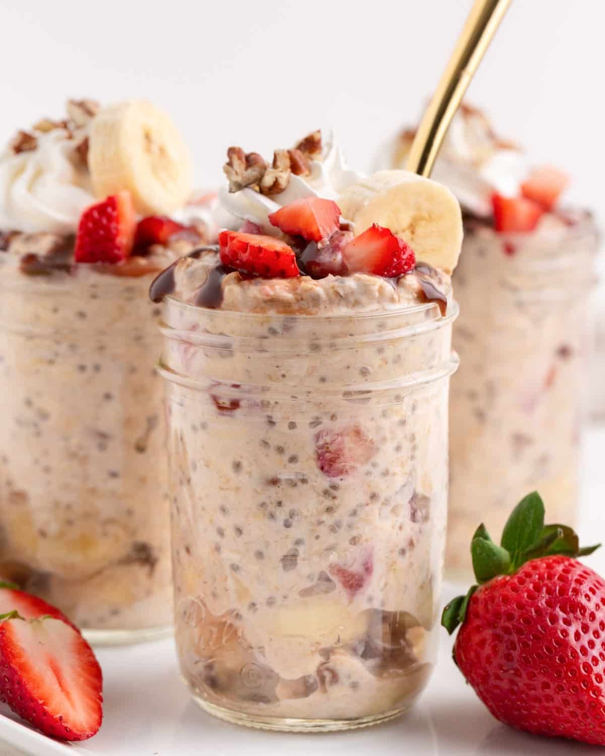 strawberry banana overnight oats in a mason jar with a spoon
