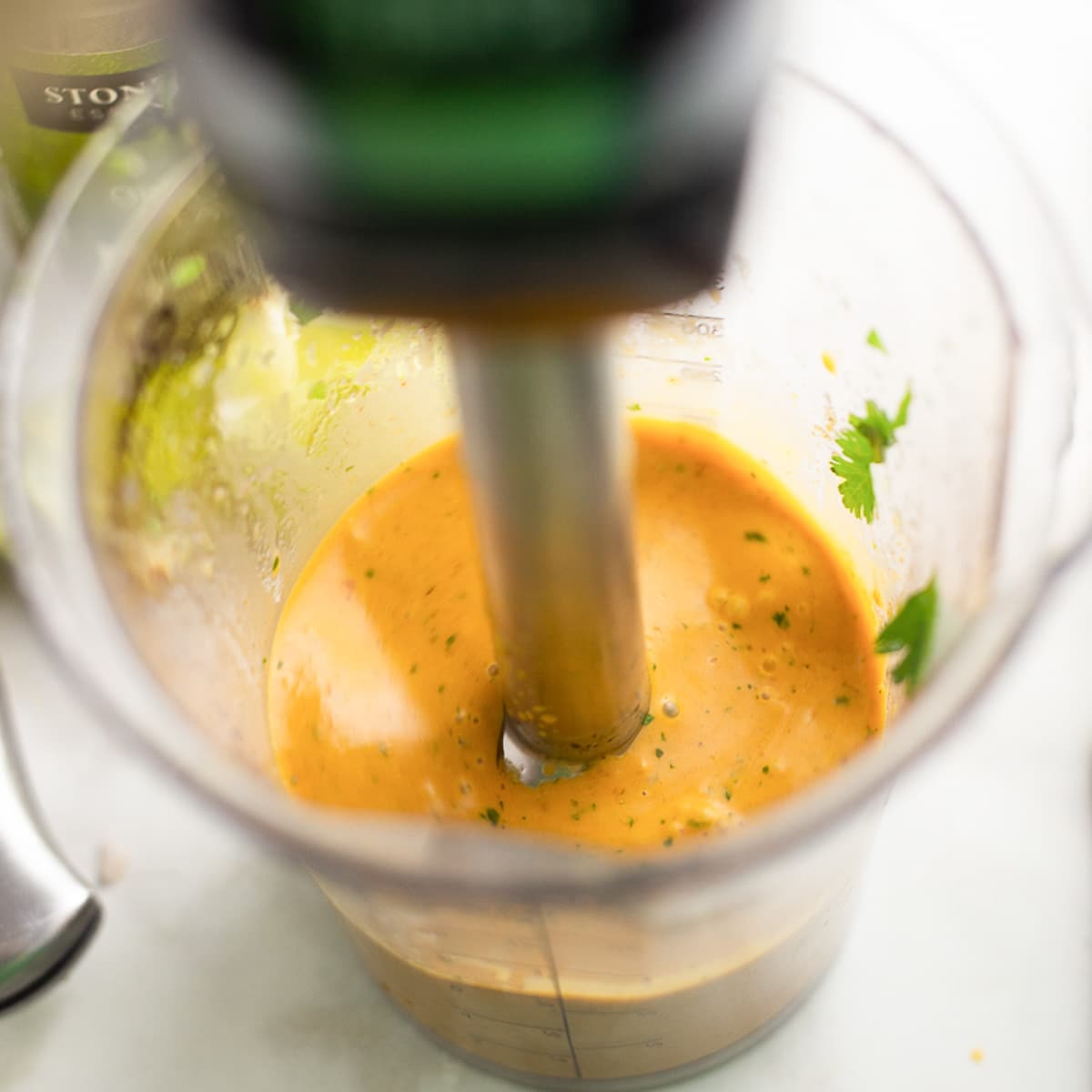 an immersion blender blending dressing