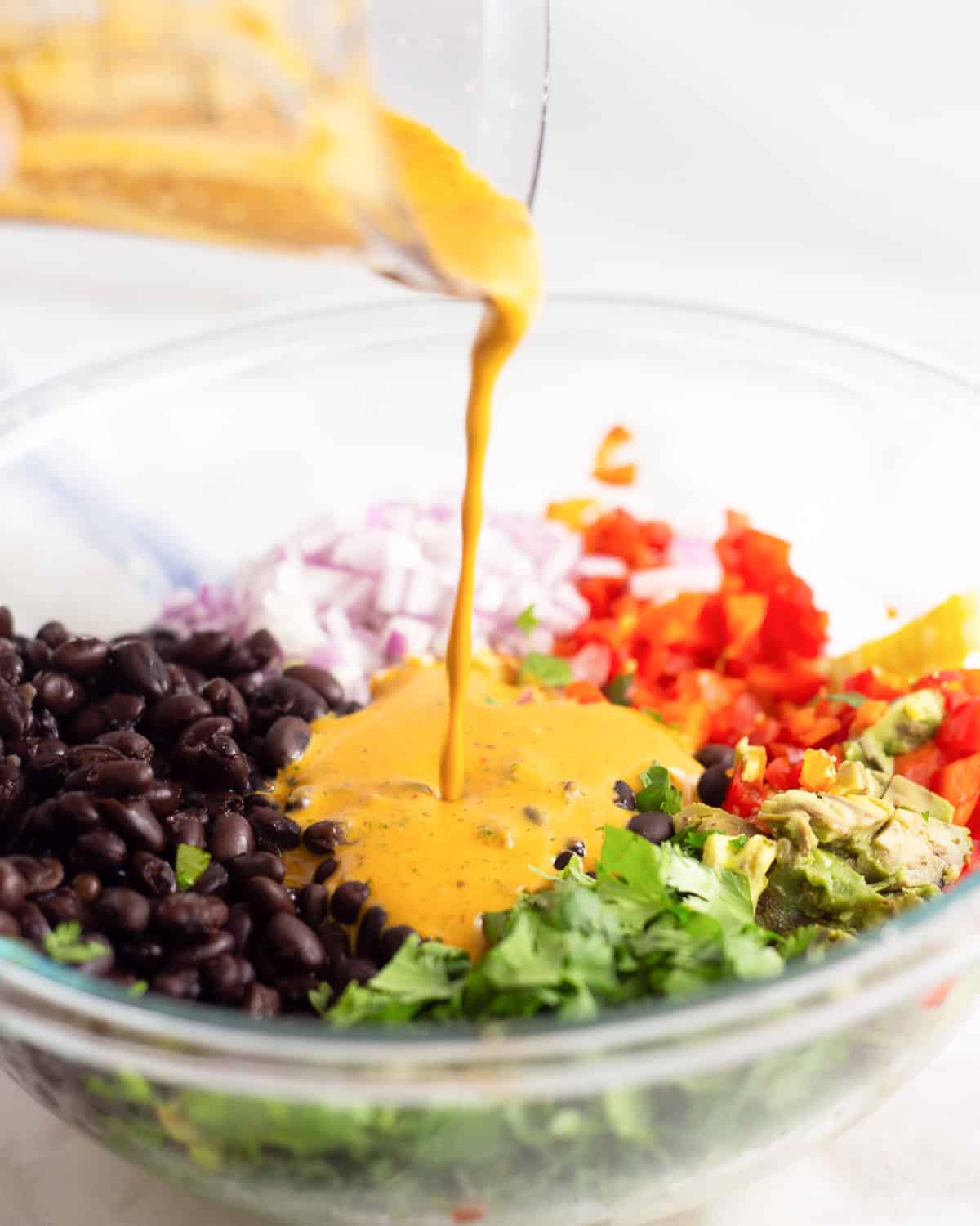 pouring salad dressing over a salad