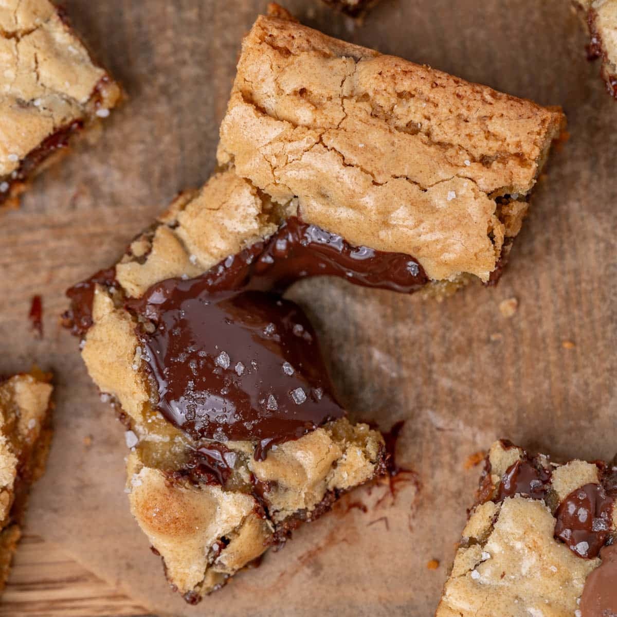 a cookie bar broken in half with a pudding of chocolate on top