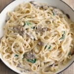 a skillet of pasta with mushroom alfredo sauce