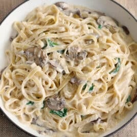 a skillet of pasta with mushroom alfredo sauce