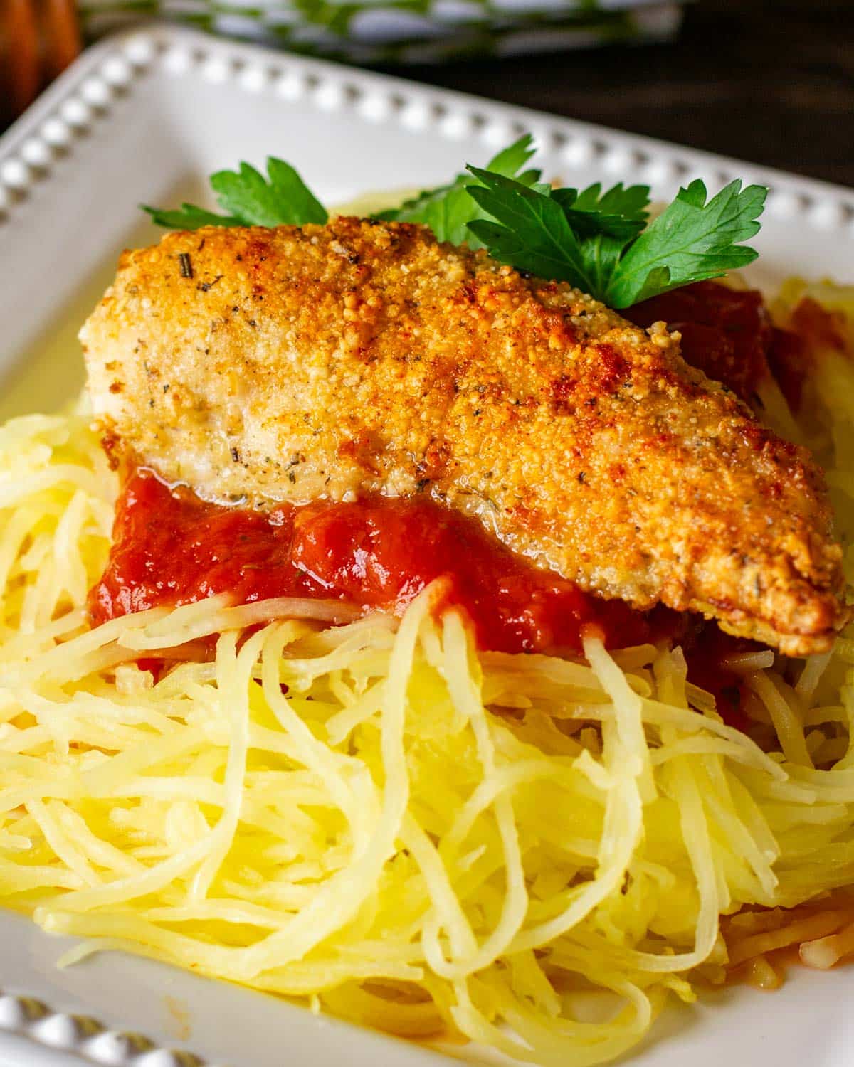 a gluten free chicken strip on a bed of spaghetti squash