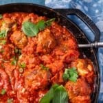 closeup of mozzarella stuffed meatballs in a cast iron skillet