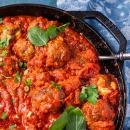 closeup of mozzarella stuffed meatballs in a cast iron skillet