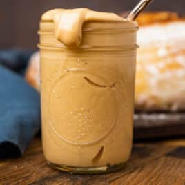 amish peanut butter spread in a glass jar with a spoon