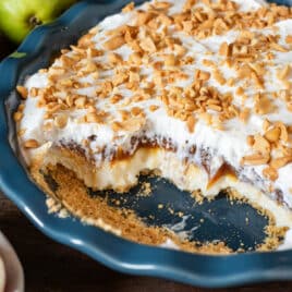closeup of a 4 layer caramel apple cheesecake dip in a pan