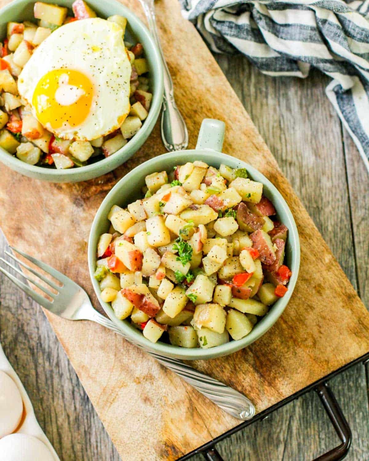 two bowls of potatoes, one with an egg on top