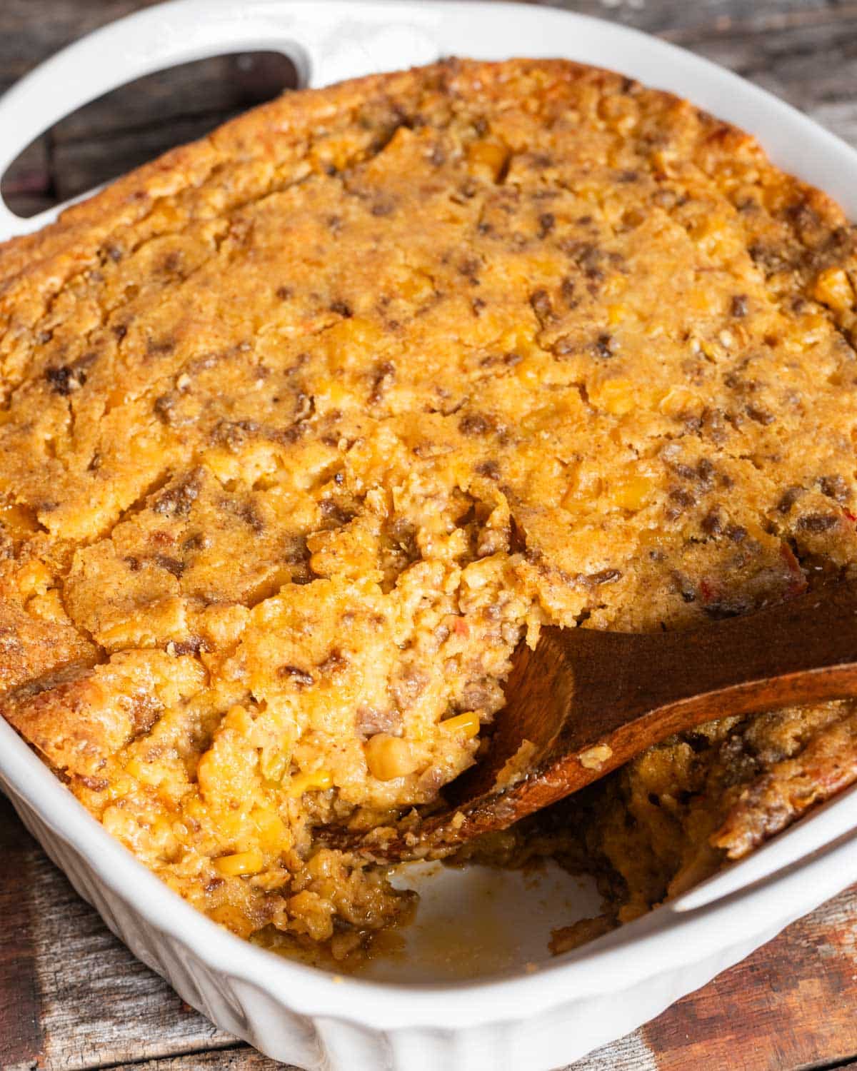 overhead view of taco corn casserole with a wooden spoon