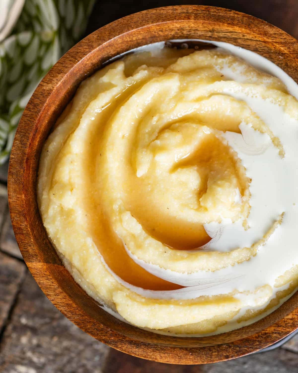 overhead view of a bowl of cornmeal mush with cream and syrup