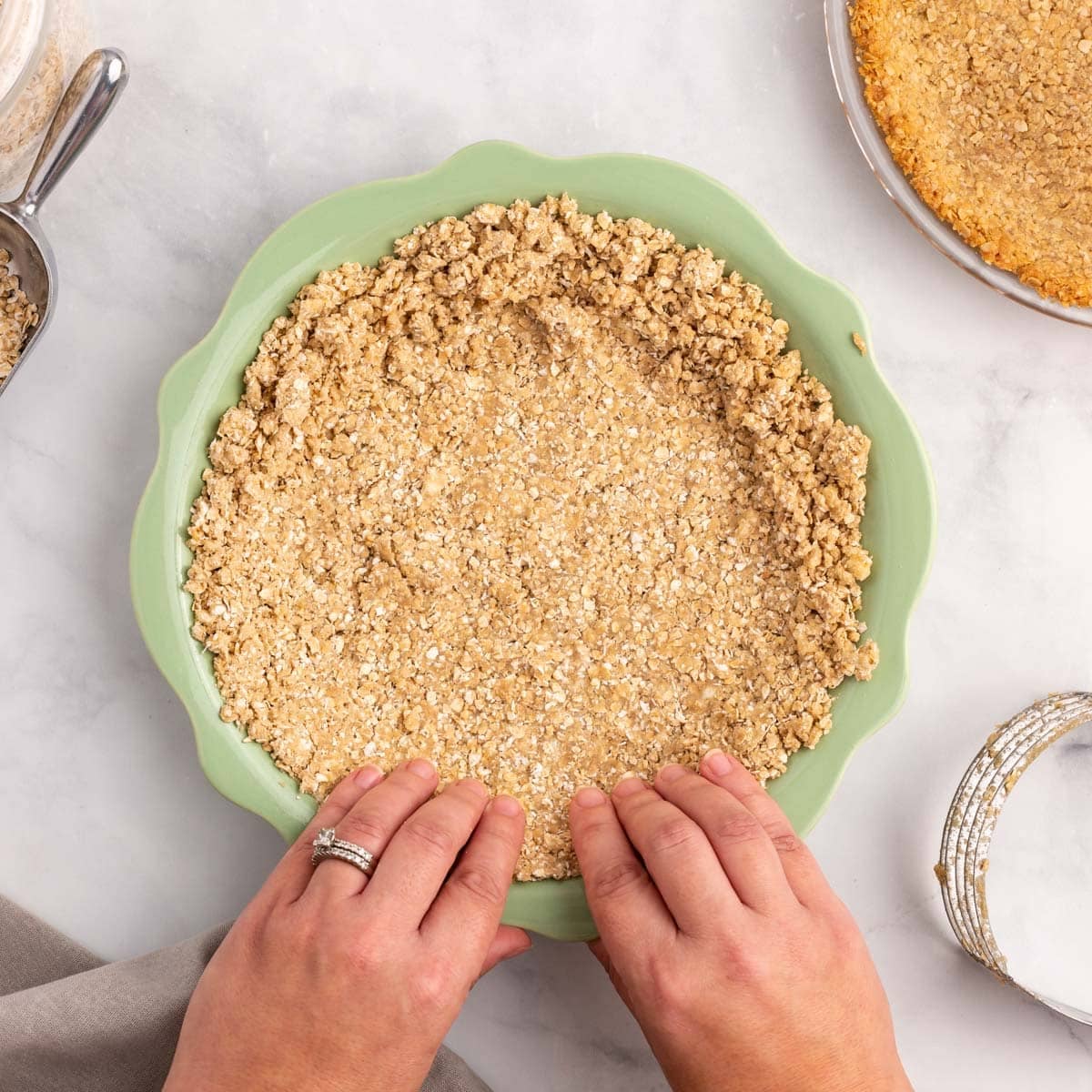 pressing oatmeal pie crust in a pan