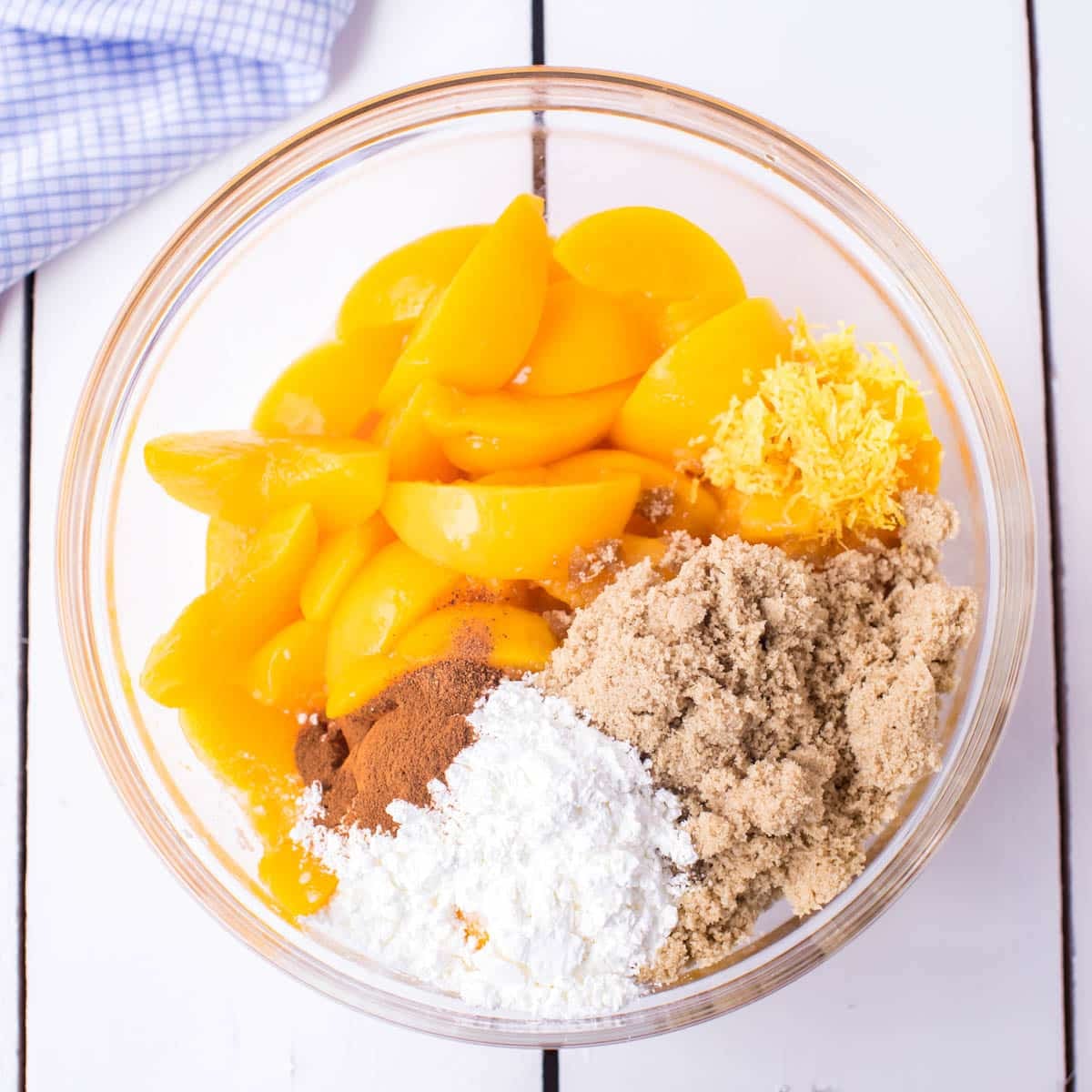 peaches, sugars, cornstarch, cinnamon and lemon in a bowl