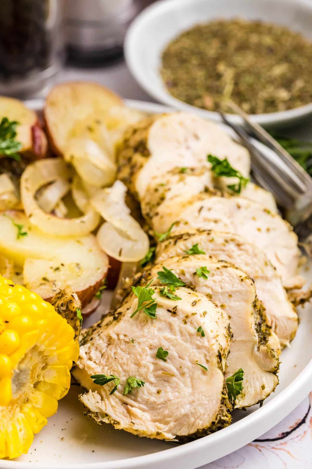 sliced chicken on a plate with potatoes and onions