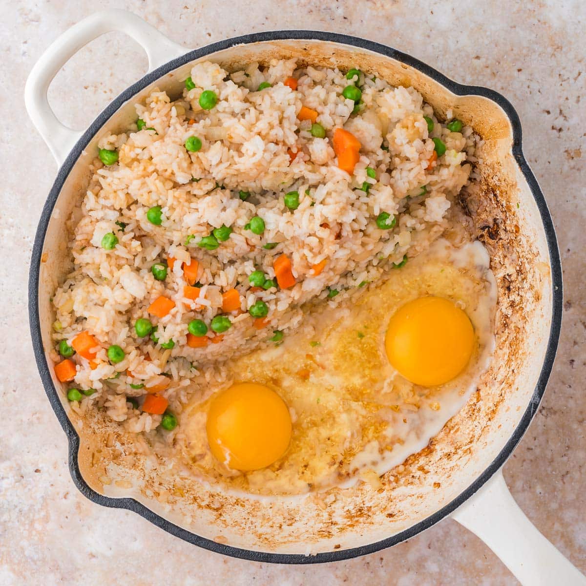 fried rice with uncooked eggs in a skillet