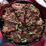 closeup of skillet meatloaf with barbecue sauce and parsley on top